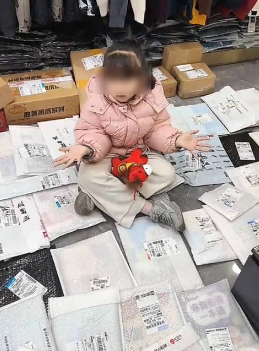 女童无奈地坐在大批网友快递来的各种寒假作业堆里。(取材自极目新闻)
