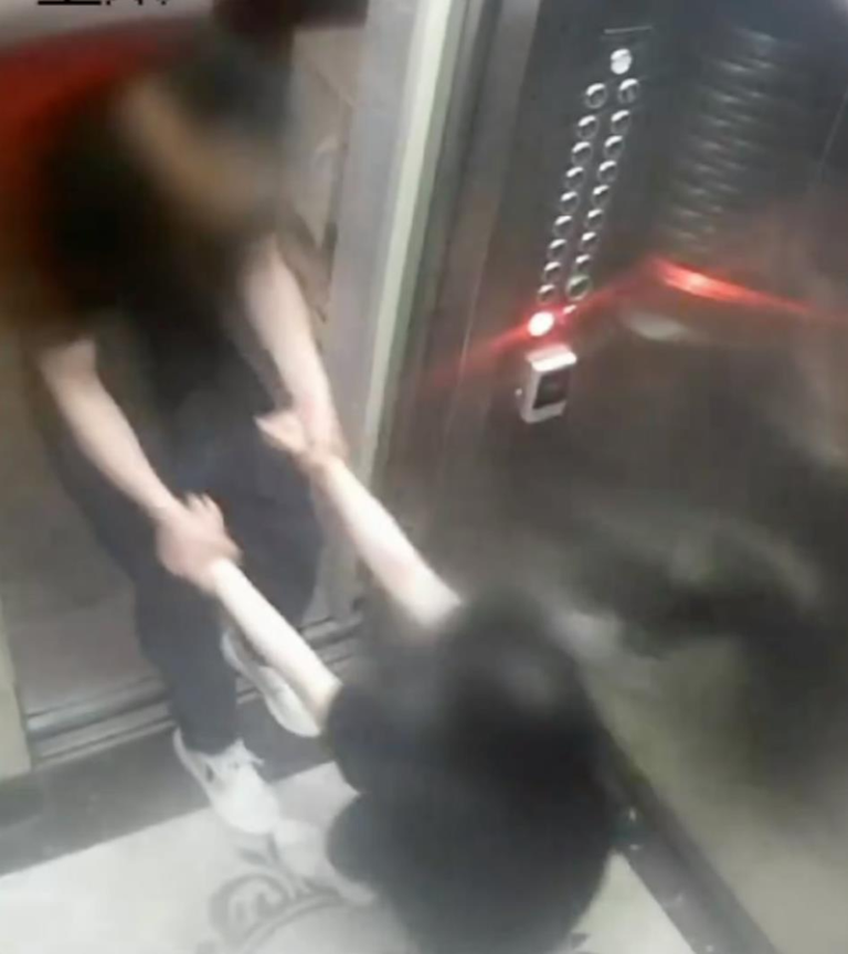 山西订婚强奸案 央视曝男子强拖未婚妻画面 席某某在电梯里紧拉吴某手臂,女方多次激烈挣扎欲逃离。(视频截屏)