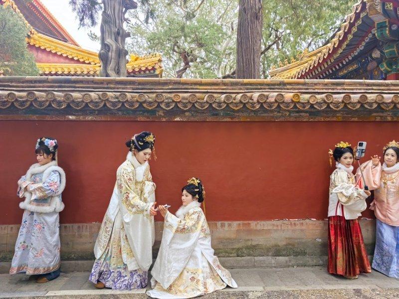 拿手机还带着男眷和婴儿车的「娘娘」与「格格」。(取材自智能财经)