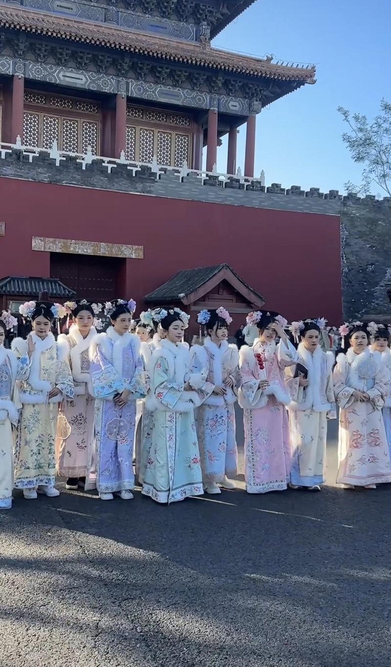 拿手机还带着男眷和婴儿车的「娘娘」与「格格」。(取材自智能财经)