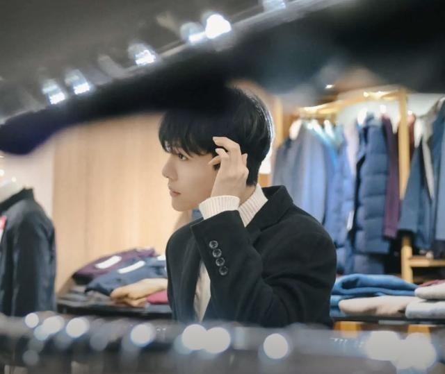 马维健帮忙试穿家中服饰店的衣服，拍摄视频做宣传。(取材自南国今报)