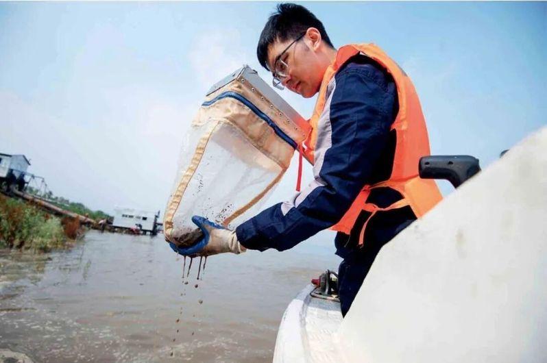 2024年4月7日下午，湖北宜昌市，人们在长江岸边观看江豚在江中嬉戏。（取材自中新周刊/视觉中国图）