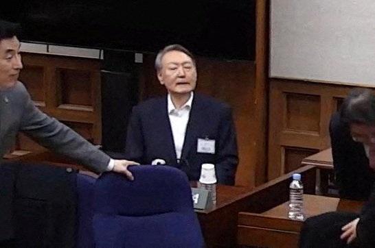 南韩前总统尹锡悦(中)19日在首尔中央地方法院出庭,他因非法戒严被判内乱罪成立,一审判处无期徒刑,逃过检方求处的死刑。(路透)