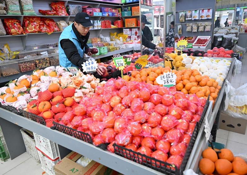 马高杰(左)把年货拿给村民。(新华社)