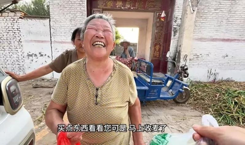 马高杰(左)把年货拿给村民。(新华社)