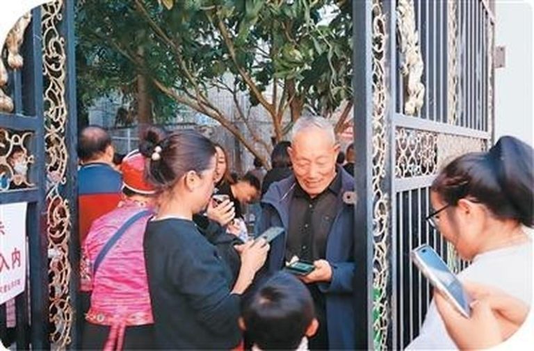 冯元勇园长(中)开门迎接游客。(取材自人民日报海外版)