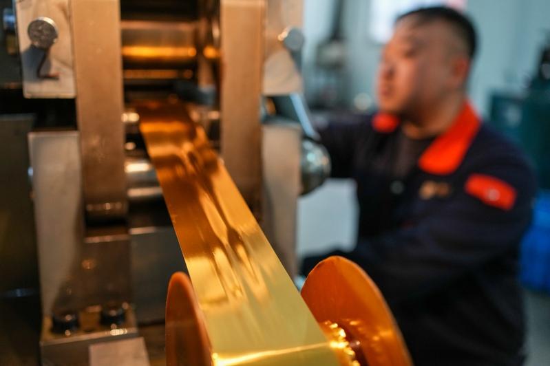 金箔锻制技艺,俗称「打金箔」,历史悠久。图为南京金陵公司工作人员在展销中心展示生肖马年金箔产品。 (新华社)