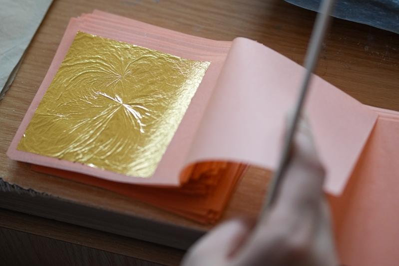 金箔锻制技艺,俗称「打金箔」,历史悠久。图为南京金陵公司工作人员在展销中心展示生肖马年金箔产品。 (新华社)