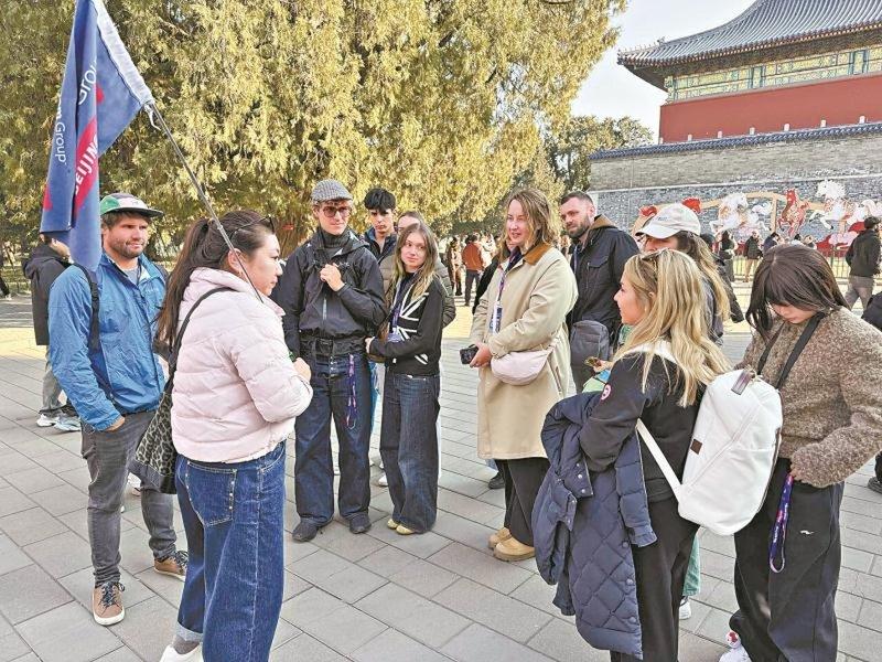 在春节期间,英语导游张赛带着外国游客参观天坛公园。(本报北京传真)