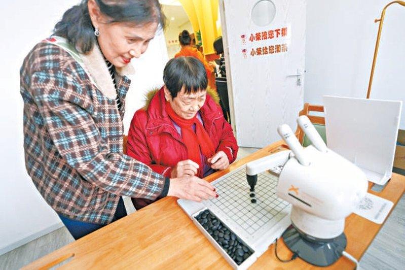 位于北京亦庄的「智能康养机器人养老驿站」,长者与机器人对弈。(取材自北京日报)