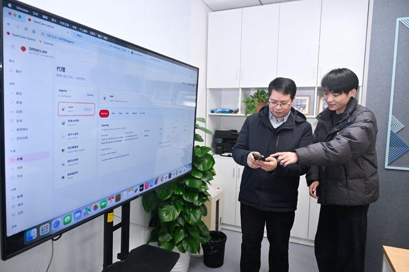 在江苏省南京市,一名技术人员(右)在安装开源OpenClaw后与用户交流。(新...
