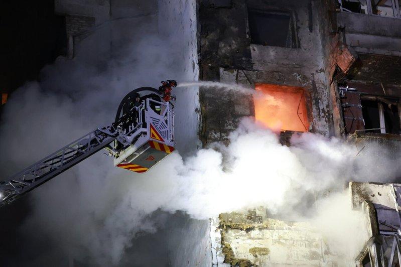 乌克兰南部的札波罗热市,24日凌晨遭俄国无人机攻击,一栋高楼住宅起火。图为消防员...