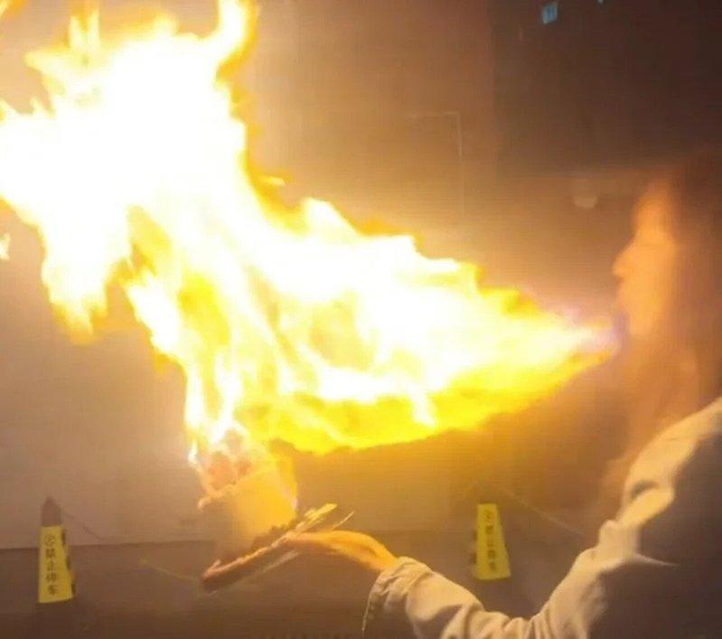 王添羽口中含了一口高浓度白酒,准备喷向已点燃的生日蜡烛上,制造网上流行的「喷火蛋...