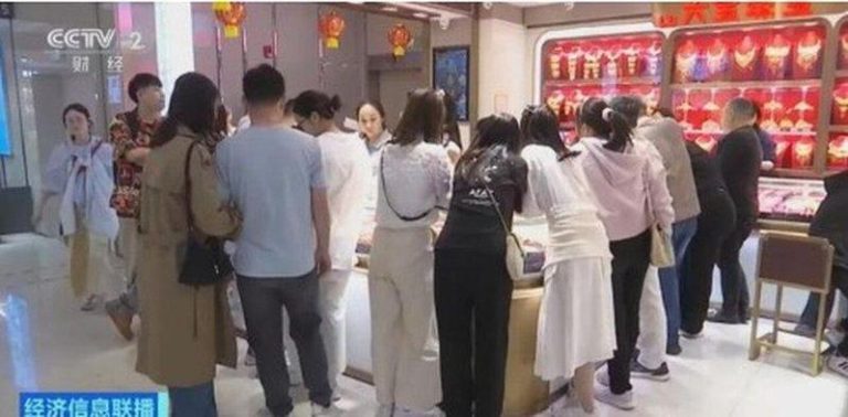 金价「黑色星期一」 中掀抄底热潮 消费者挤满金店柜台 投资金条的消费者挤满柜台。(央视截屏)
