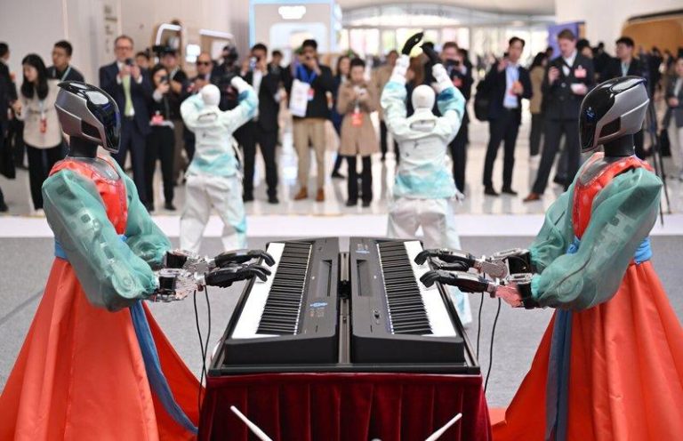 「词元」搜索量飙18倍 掀算力涨价潮 国产AI「超级底座」发布 3月27日,国产AI算力 「超级底座」众智FlagOS 2.0正式发布,实现对32款AI芯片的全场景支持。图为2026中关村论坛年会活动现场,人形机器人乐队进行演奏。 (中新社)
