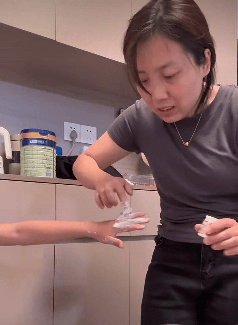 小男孩在家将灭火毯平铺在床上玩，不慎被扎，妈妈崩溃。（视频截屏）