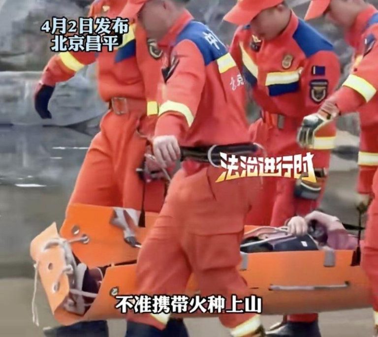 女子上了担架，由五名消防人员扛下山。（取材自新闻晨报）