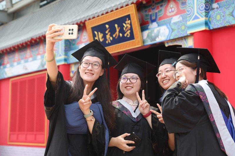 去年中国出国留学人数超57万,回国人数则达53.56万。图为北京大学毕业生拍照留...