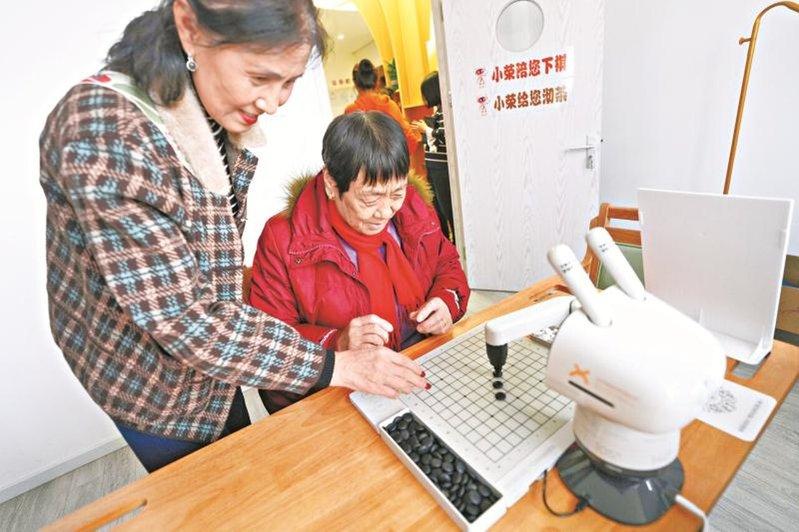 全球首个智能康养机器人养老驿站在北京荣华街道启动运营,老人在驿站内与机器人对弈。...