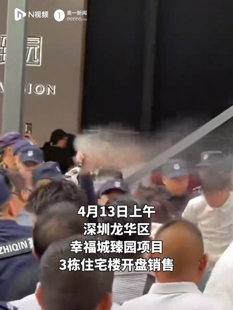 深圳一楼盘遭哄抢，保安向人群喷辣椒水。（视频截屏）