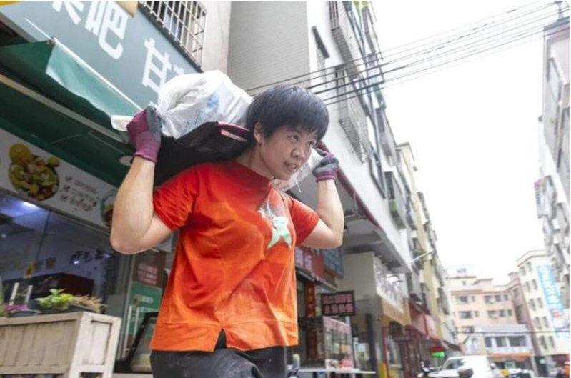 魏云桂在搬着建筑垃圾下楼。(取材自广州日报)