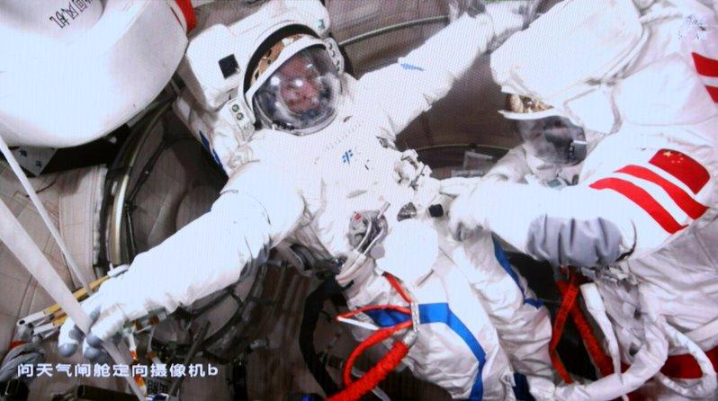 4月16日在北京航天飞行控制中心屏幕上拍摄的神舟21号乘组航天员武飞(左)与张陆...