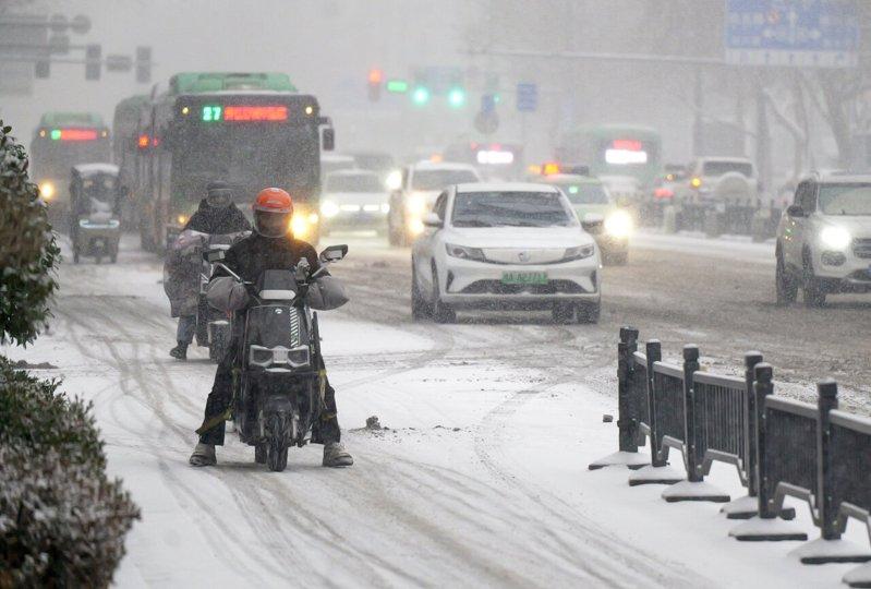 一名外卖员冒雪行进在街头。(新华社)