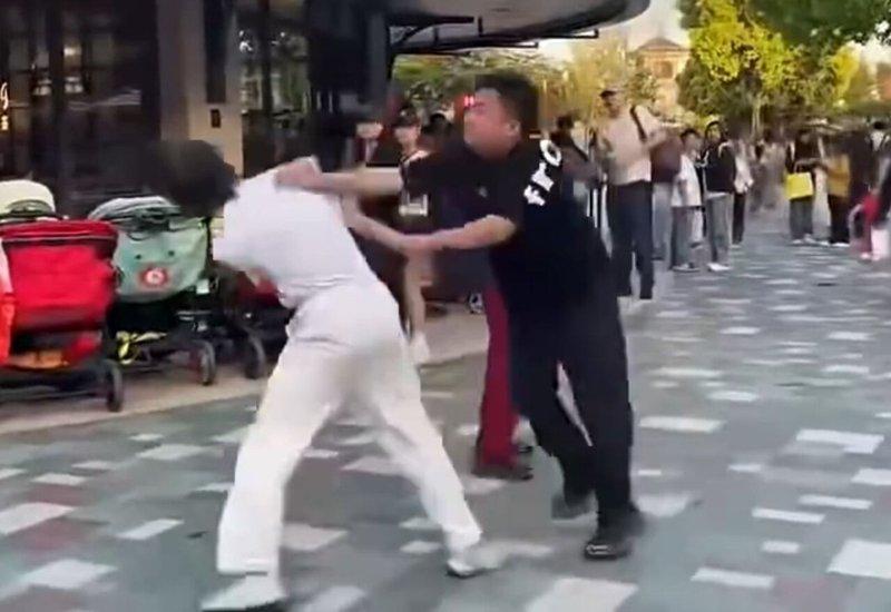白衣男因劝阻吸烟被黑衣汉追打。(视频截屏)