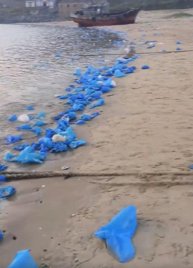 福建平潭岛海岸在线出现了大量被丢弃的蓝色一次性塑料鞋套,网友无奈讽刺「晚上蓝眼泪...
