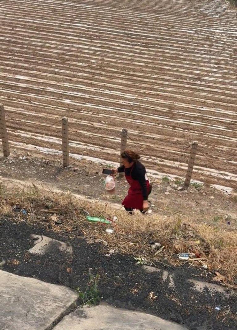 五一高速路堵车点外卖 甘肃老板娘排除万难真的送来了 女老板穿着围裙穿越田地、爬上边坡送外卖。(取材自潇湘晨报)