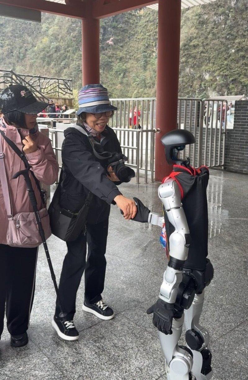 人形机器人在景区与游客握手。(取材自微博)