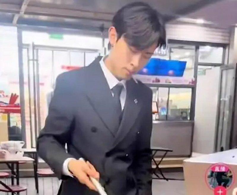 山东烟台一名19岁小伙穿西装夜市摆摊卖炒饭。(视频截屏)