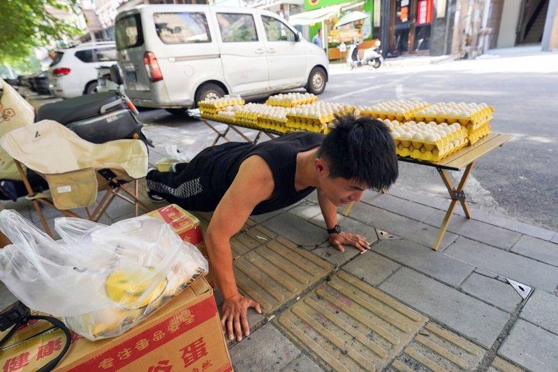 摊位前做俯卧撑的熊傲林。(取材自极目新闻)