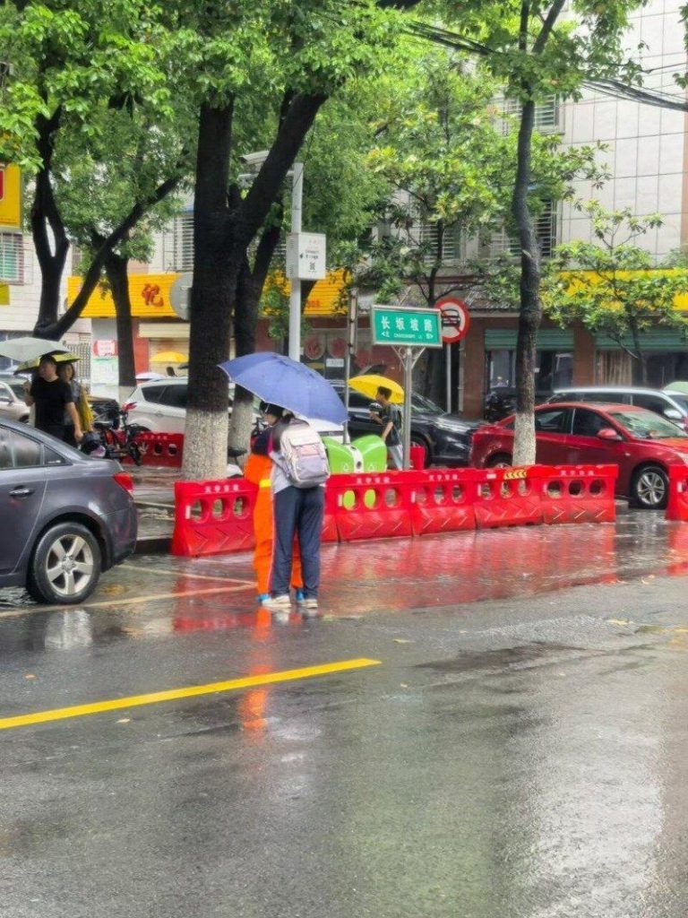 「鞋袜湿怎上课」 湖北环卫工雨中背50学生蹚水过马路 湖北一名环卫阿姨挺身而出化身「摆渡人」,陆续背了近50名学生蹚水过马路。(取材自...