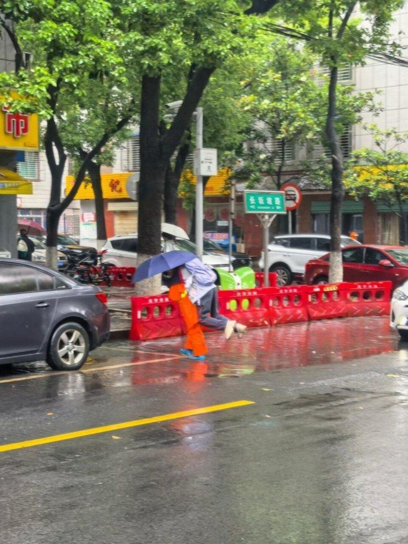 湖北一名环卫阿姨挺身而出化身「摆渡人」,陆续背了近50名学生蹚水过马路。(取材自...