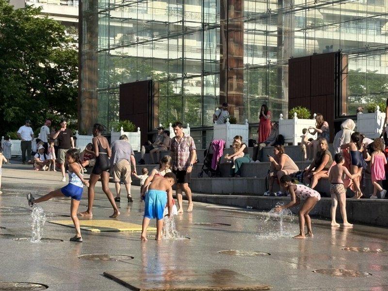 法国出现罕见的5月酷热天气,巴黎不少家长带孩子到公园戏水,自己也略享清凉。(中央...