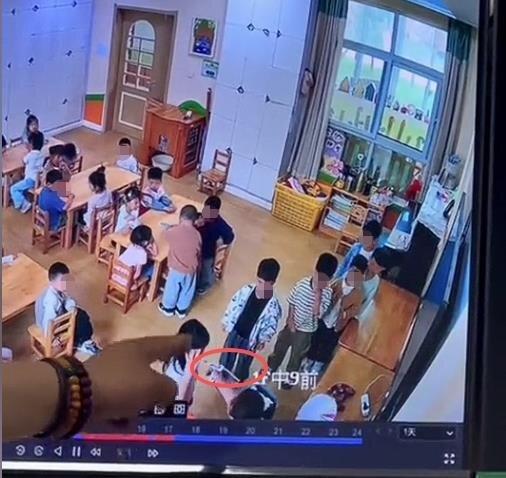 红圈处是涉事女老师拿着热熔枪正往受害幼童的嘴唇逼近,一旁还有多名学童排着队围观。...