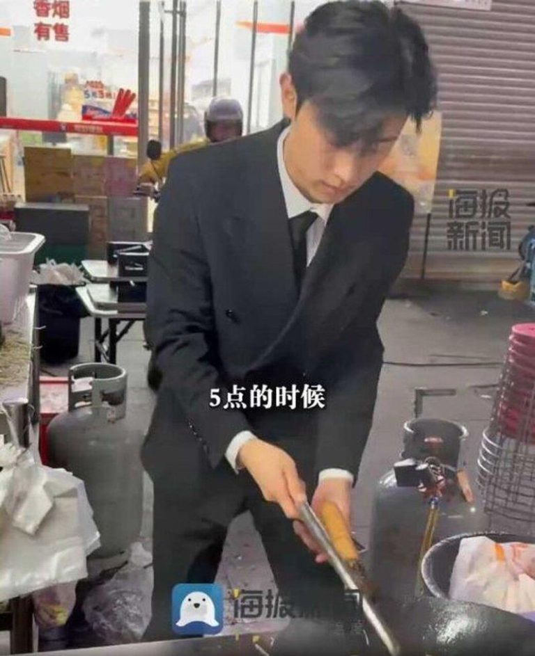 山东烟台一名19岁小伙穿西装夜市摆摊卖炒饭。(视频截屏)