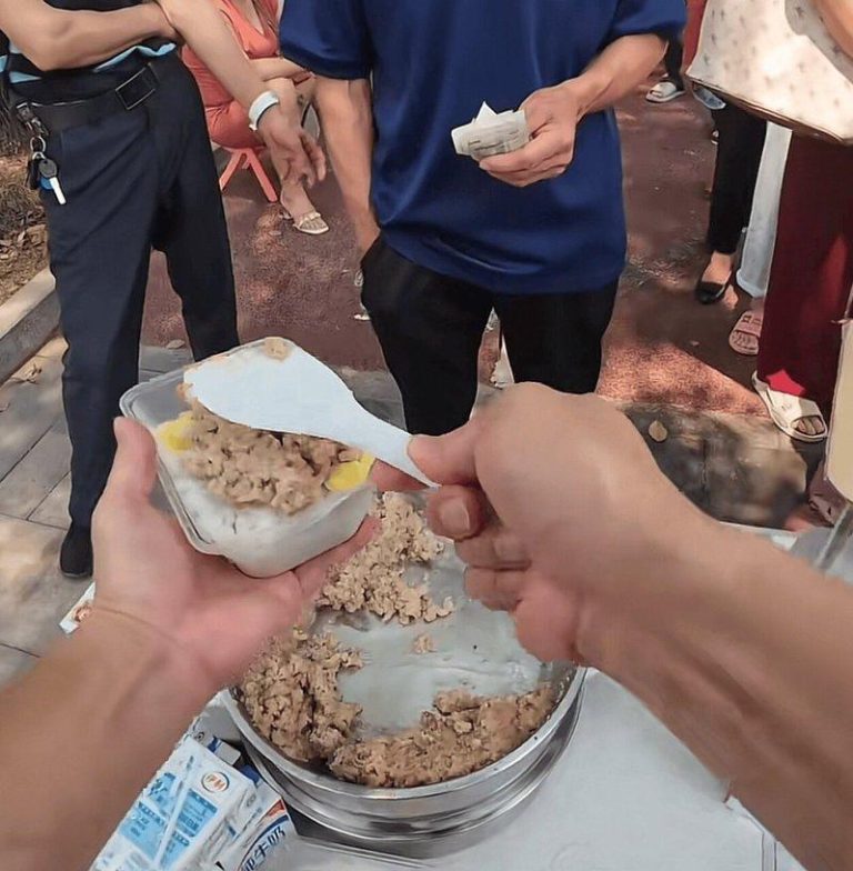 广西男医院前卖3元盒饭 早起买菜、风雨无阻 原因感人 阿六在打饭。(取材自九派新闻)