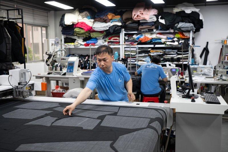 一家服饰公司工作人员用激光裁剪设备制作样衣。示意图。(新华社)