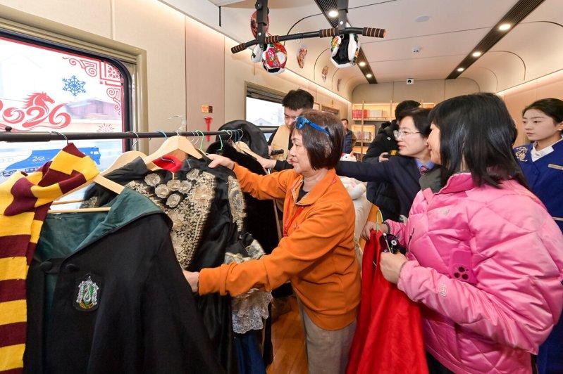 「悠享龙江·银旅号」列车为旅客打造移动「照相馆」，车上提供旅拍服饰，图为游客正在...