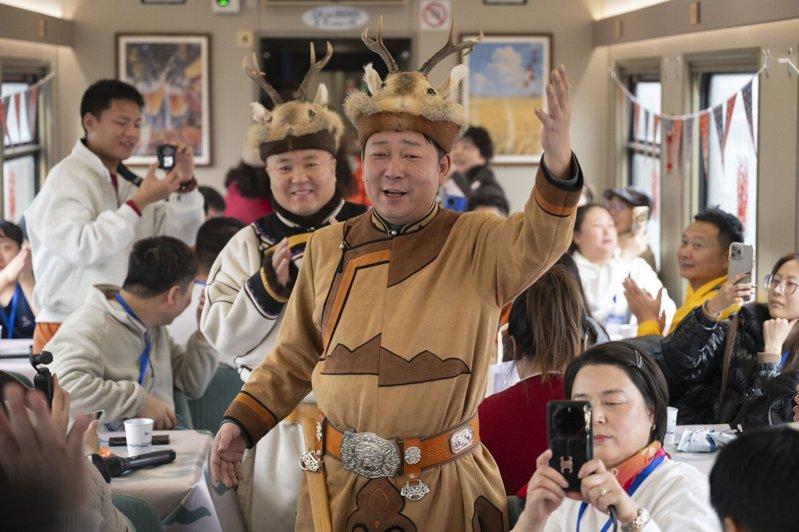 在「悠享龙江·银旅号」旅游列车上，鄂伦春族演员在表演。（新华社）