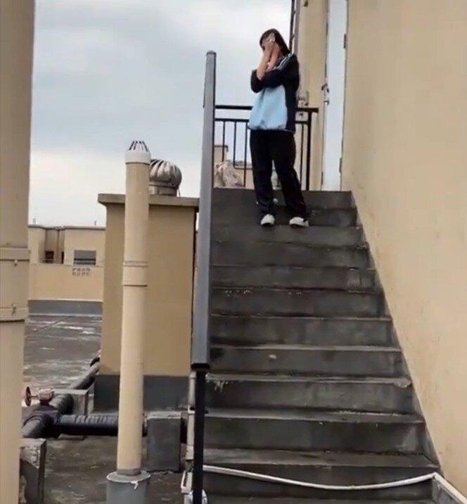 疑似欺凌者捂着脸怕被拍到脸。(视频截屏)