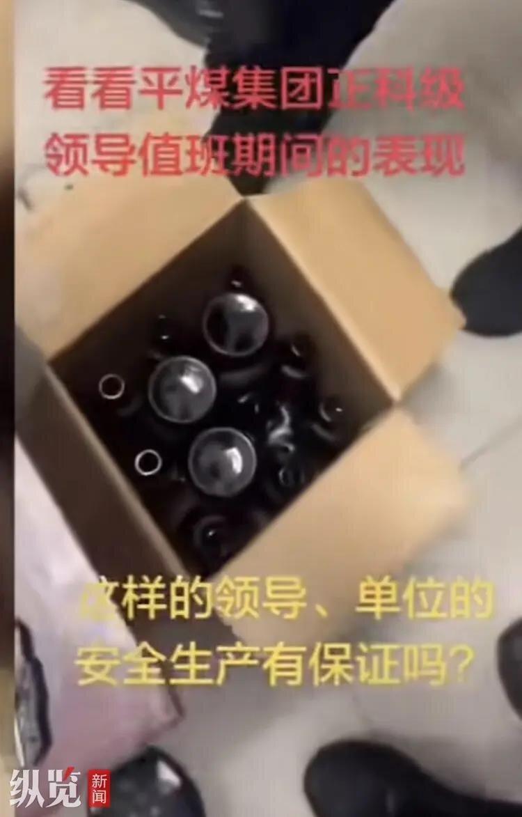 地上纸箱里堆放的疑似为啤酒瓶。(视频截屏)