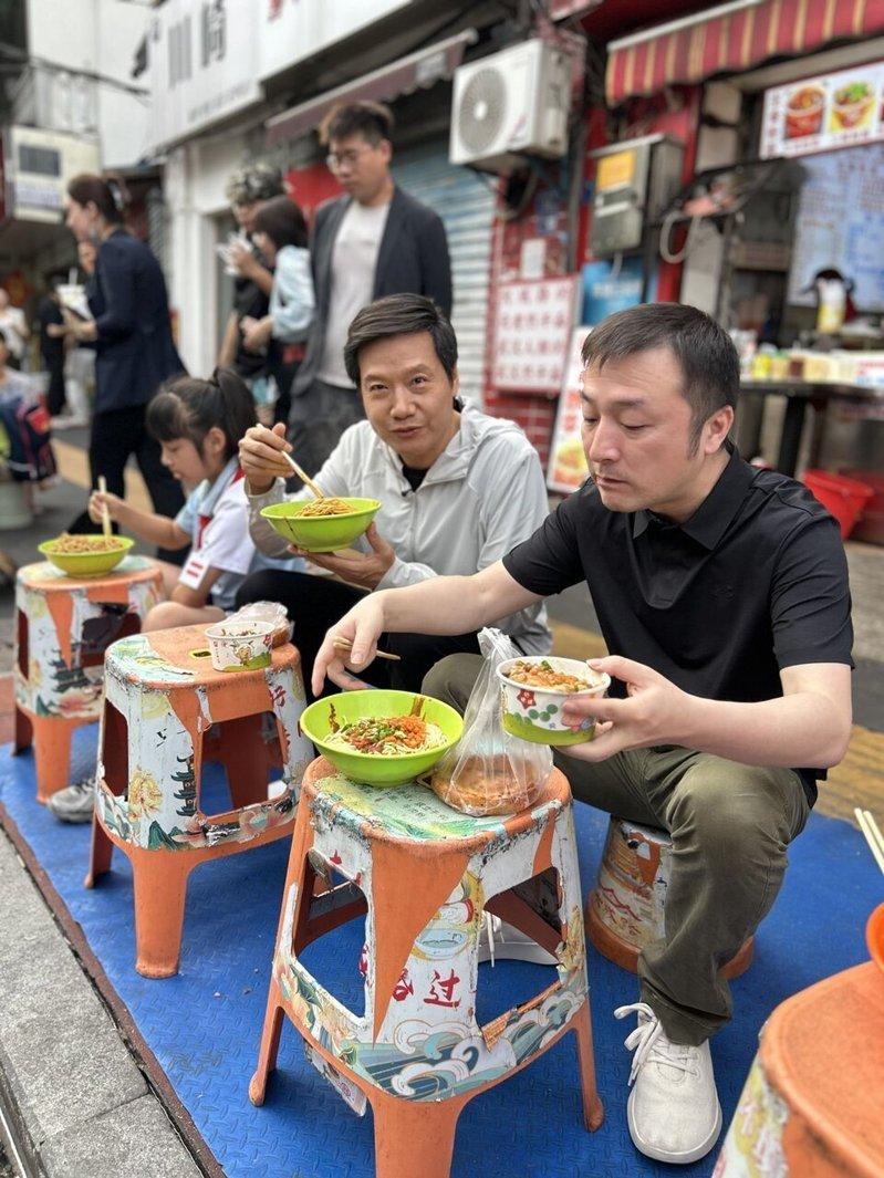 雷军(中)蹲武汉路边「过早」。(取材自极目新闻)