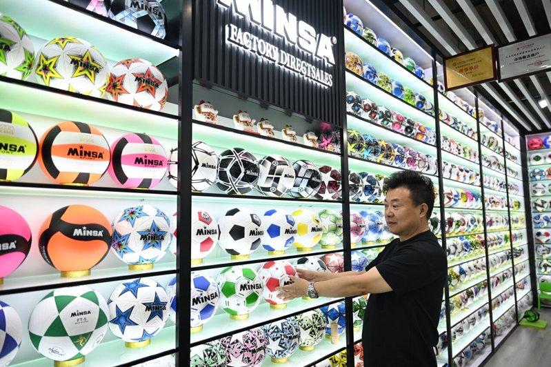 「小商品之都」义乌的商户陈绍美展示各类世界杯纪念足球。(中新社)