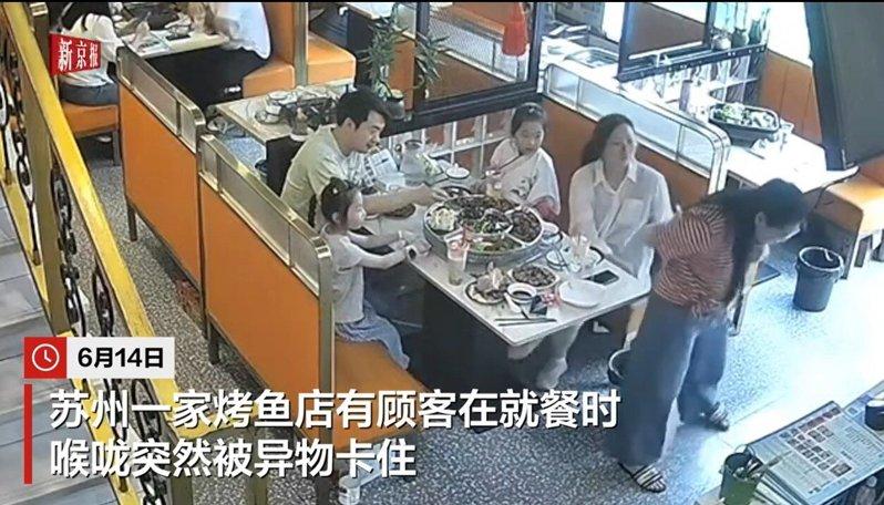 女子（右前方）在烤鱼店用餐时被异物卡喉。（视频截屏）