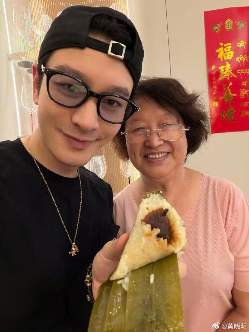 黄晓明晒出与母亲的合照,手上拿着的是妈妈包的红枣粽子。(取材自微博)