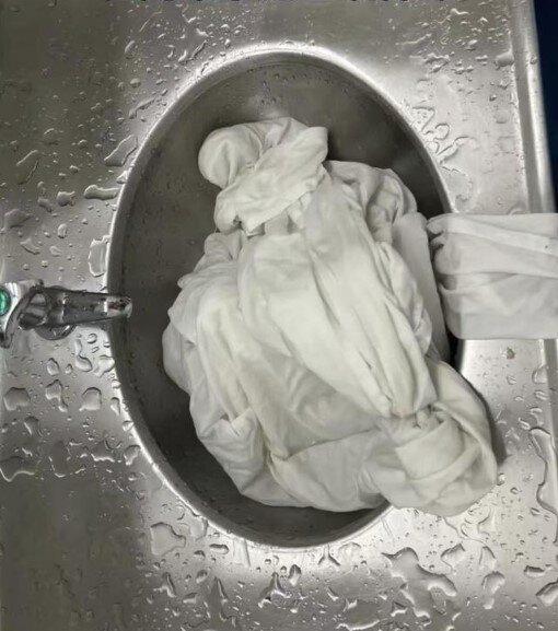 张女士在水池清洗床单。(取材自极目新闻)