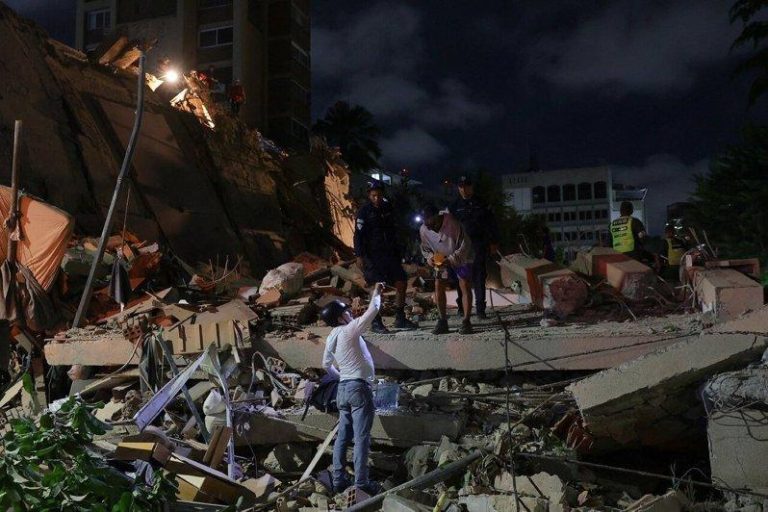 委内瑞拉首都卡拉卡斯24日发生地震后，紧急救援人员在倒塌建筑物现场展开救援工作。...